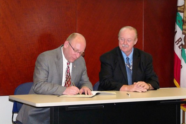 2 men signing paperwork