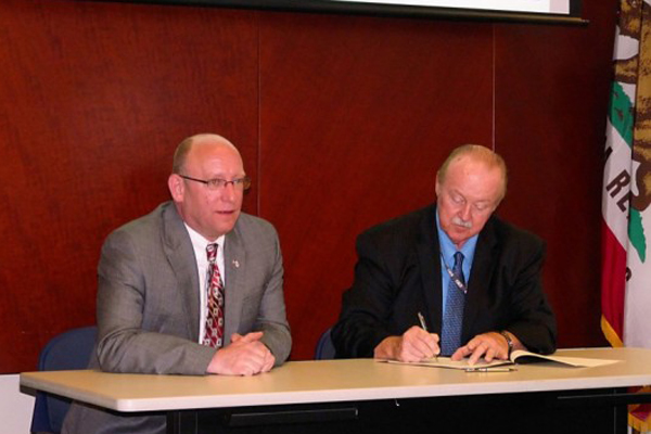 2 men signing paperwork